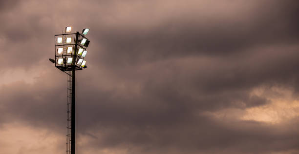 estádio de esportes brilhantes luzes em uma noite nublada - floodlight blue sky day - fotografias e filmes do acervo