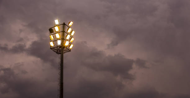 istock Bright sports stadium lights on a cloudy evening 1085165064