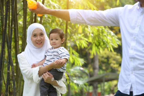 istock Happy mother playing soap bubble with her son in the park. 1085168624