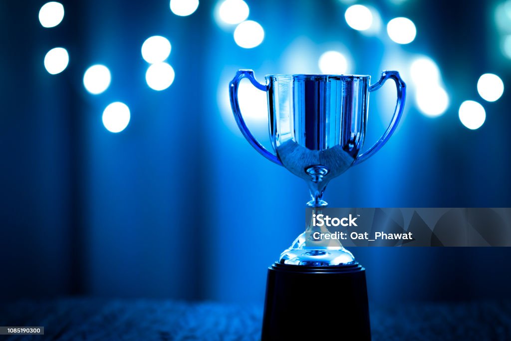 Silver Trophy competition in the dark on the abstract blurred light background with copy space, Blue Tone Trophy - Award Stock Photo