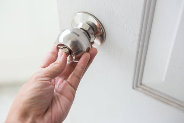 istock Hand holding a door knob on a white door 1085194306