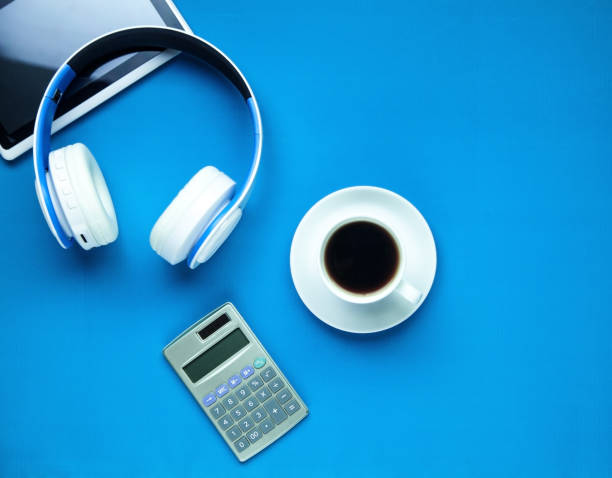 istock Headphones, tablet, calculator and coffee cup on a blue background. 1085197768