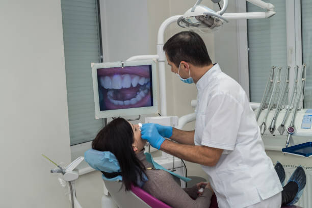 dentista, verificando os dentes do paciente com câmera em estomatologia - medical exam dental hygiene caucasian mask - fotografias e filmes do acervo