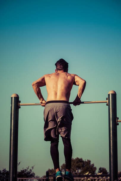 istock Young man exercising on gymnastic bar at park 1085199626