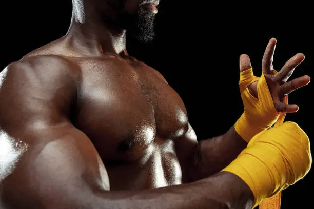 Photo of Afro American boxer is wrapping hands with bandage