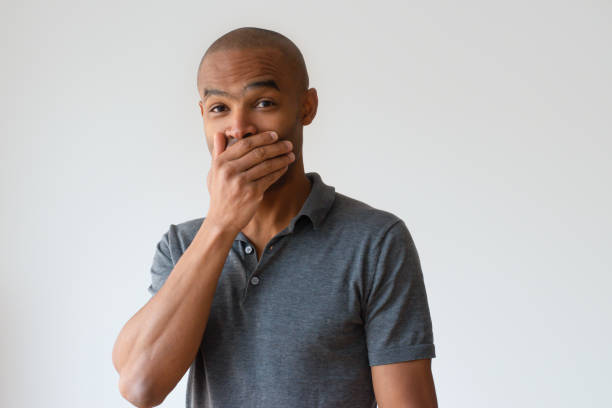 Joyful black guy trying not to laugh