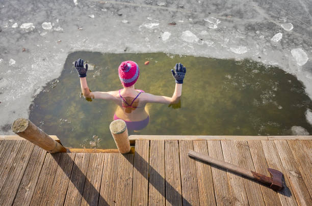 istock Fit woman performs ice swim in the ice hole. 1085205940