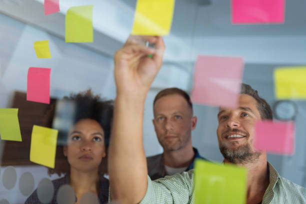 istock Coworkers discussing new ideas on a glass wall 1085208928