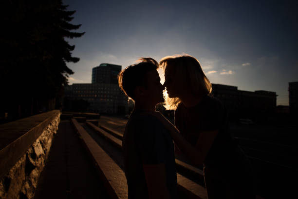 pareja besándose en el parque durante la puesta de sol - silhouette kissing park sunset fotografías e imágenes de stock