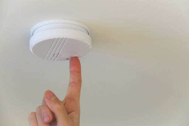istock A person push the test button on a automatic smoke detector fire alarm in the ceiling. 1085213958