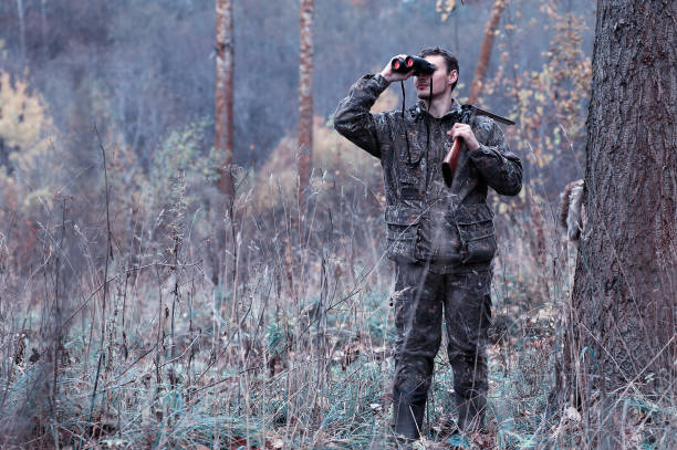 istock A man in camouflage and with a hunting rifle in a forest on a spring hunt 1085214004