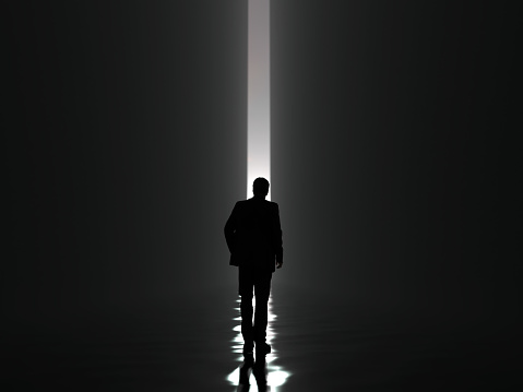 businessman walking towards the light