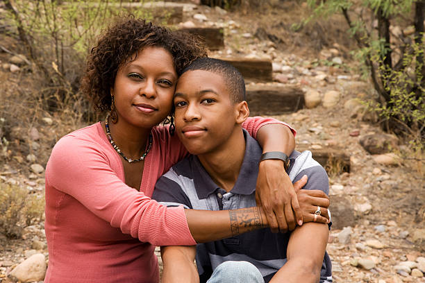 African-American single-parent family Loving single-mother hugging her handsome teenage son tattoo photos stock pictures, royalty-free photos & images