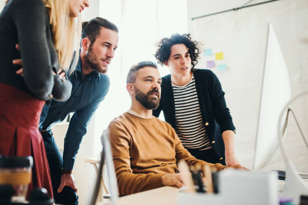 istock Group of young businesspeople with computer working together in a modern office. 1085230972