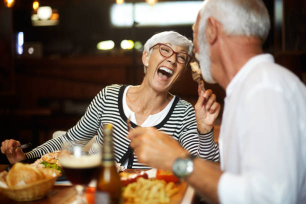 istock Elderly couple laughing while having a meal together in a restaurant 1085234334