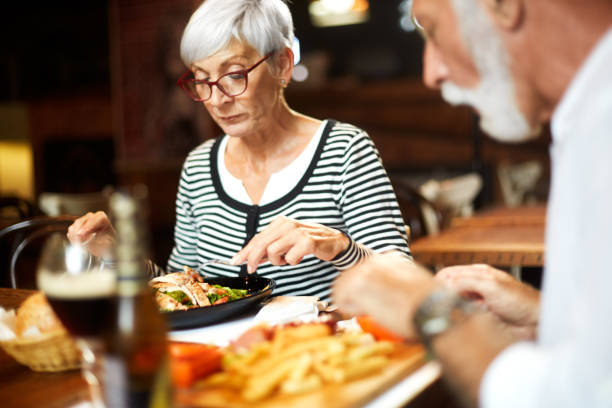 istock Elderly couple having a meal with beer in a restaurant 1085234378