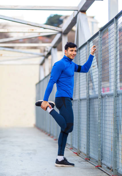 istock Young man stretching legs before workout on the bridge 1085241198