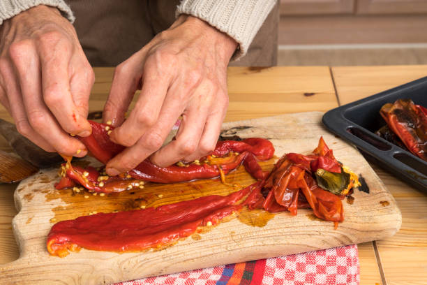 istock Peeling a roasted pepper. Removing skin and seeds with hands 1085244054