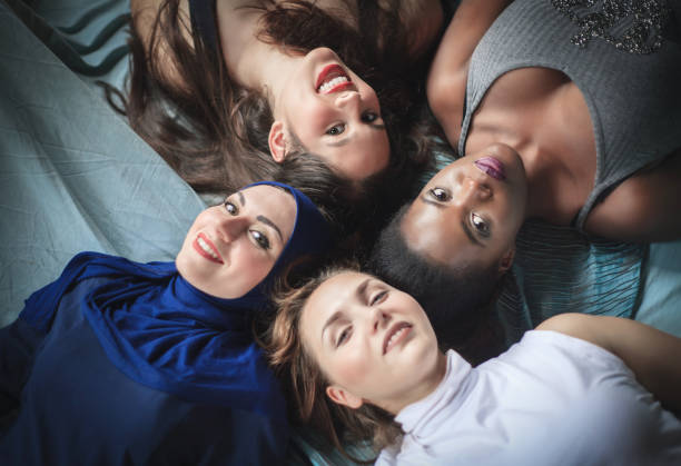 istock Four girls of different nationalities lying, studio shot. 1085246148