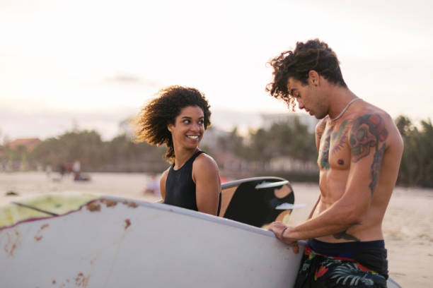 istock Young mixed race couple preparing to surf 1085249202