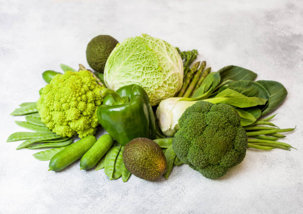 istock Assorted green toned raw organic vegetables on white background. Avocado, cabbage, broccoli, cauliflower and cucumber with trimmed and mung beans, pak choi, loose pepper and lettuce. Green energy 1085249878