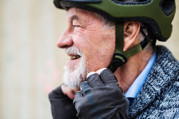 istock A close-up of active senior man standing outdoors, putting on bicycle helmet. 1085256884