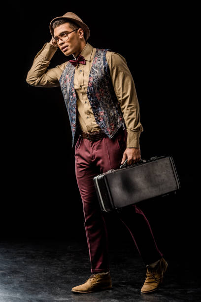 istock handsome mixed race young male jazzman posing with trumpet case on black 1085268232