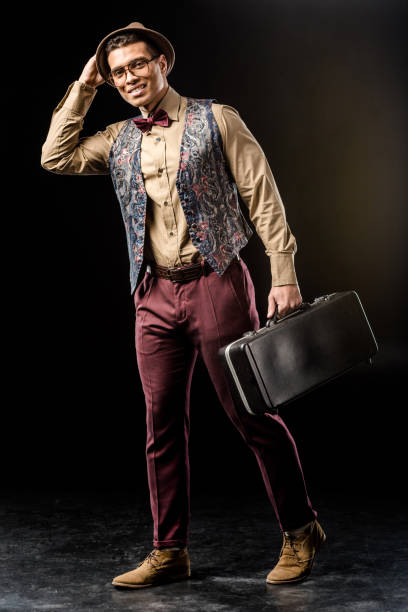 istock smiling young male jazzman posing with trumpet case on black 1085268280