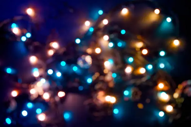 Blurred multicolored reflection from a garland on a black background.