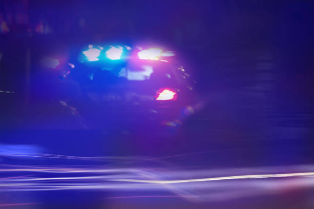 istock Police car speeding through traffic at night time 1085273748