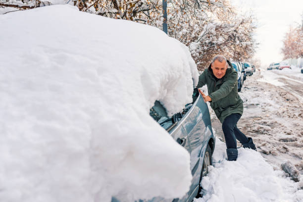 istock Man is pushing a car stuck in the snow 1085273758