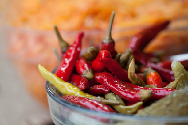 Marinated hot peppers in glassy bowl. Pickled chili peppers
