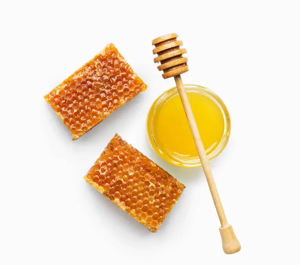 Photo of Jar full of fresh honey and honeycombs isolated on white