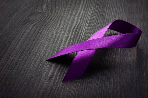 Purple awareness ribbon on a desk. Pancreatic cancer. Purple awareness ribbon on a desk. Pancreatic cancer. award ribbon photos stock pictures, royalty-free photos & images