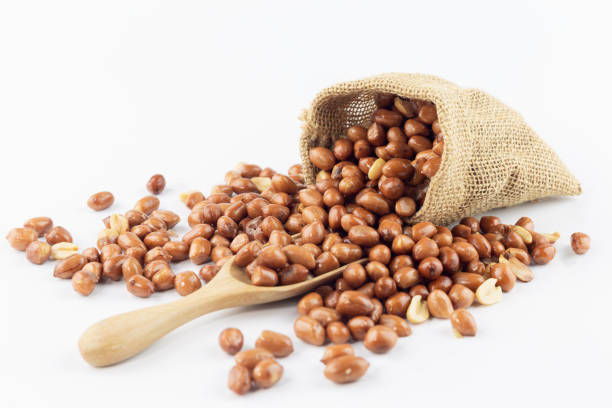 istock peanut pour out small sack with wooden spoon on white background 1085285120