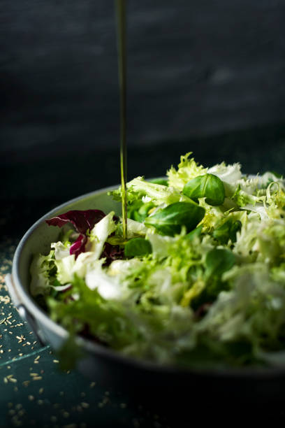 vestire un'insalata verde con olio d'oliva - green food chervil herb foto e immagini stock