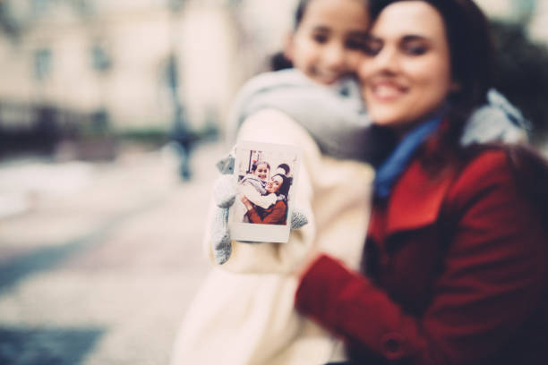 istock Mother with daughter taking instant photos together 1085294408