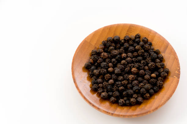 istock black pepper in a wooden dish on white background 1085297752