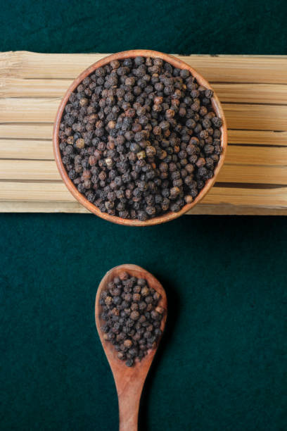 Close-Up Of Black Pepper In a bowl and spoon Close-Up Of Black Pepper In a bowlClose-Up Of Black Pepper In a bowl and spoon black peppercorn photos stock pictures, royalty-free photos & images