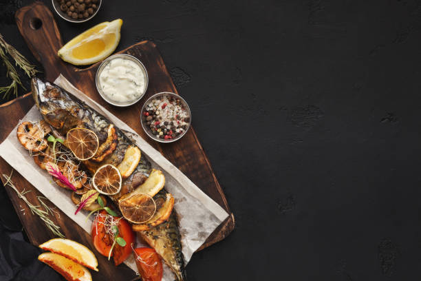 Grilled fish on wooden board at restaurant table