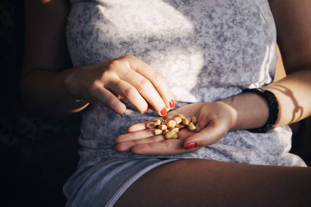 istock Midsection Of Woman Holding Peanuts 1085308942