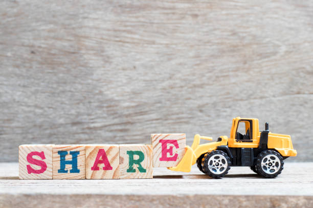 istock Toy bulldozer hold letter block e to complete word share on wood background 1085309752