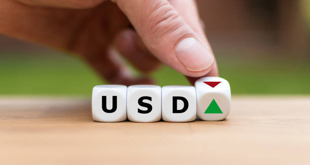 istock Hand is turning a dice and changes the direction of an arrow symbolizing that the value of the US Dollar is going up (or vice versa) 1085310590