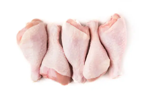 Photo of Uncooked chicken legs on white background