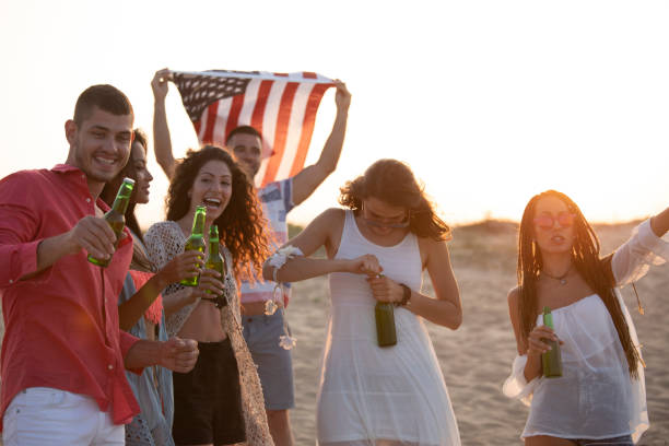 istock Friends drinking beer on beach and cheering 1085317092