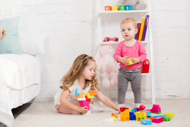 istock adorable sisters playing with constructor in children room 1085317814