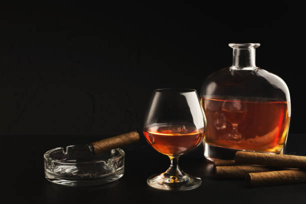 istock Glass with cognac, bottle and cigar on black background 1085322478