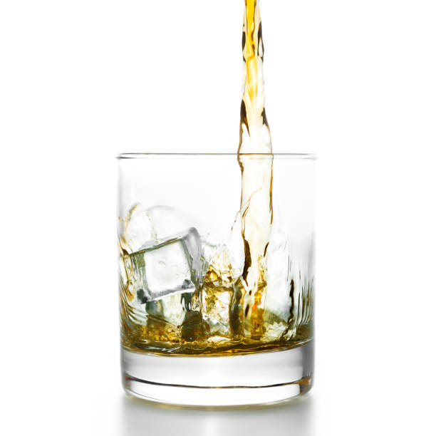 Golden whiskey pouring into lowball