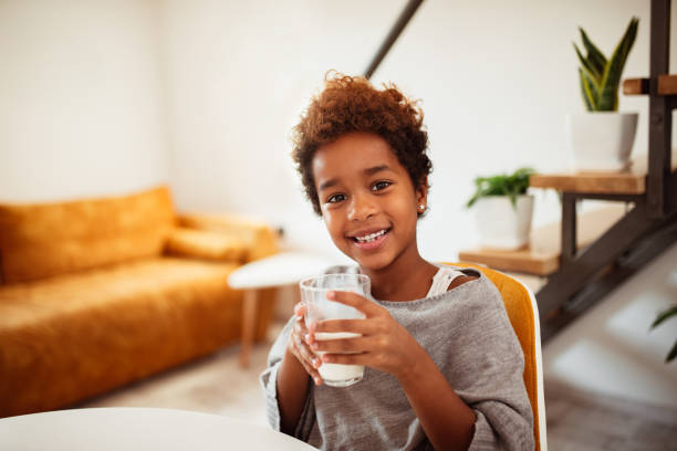 gorgeous little girl drinking a glass of milk. - milk child drinking little girls imagens e fotografias de stock