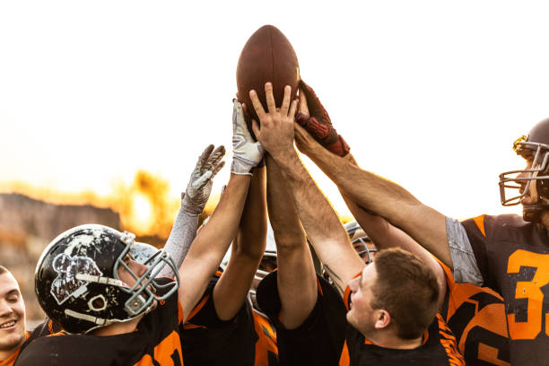 American Football Players Celebrating The Victory American Football Players Celebrating The Victory all together with raised hand in the air hand fan photos stock pictures, royalty-free photos & images